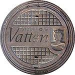 Ett brunnslock med Stockholm Vattens logotyp.