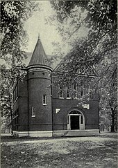 A black and white photograph of a Victorian-style fraternity house