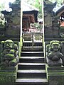 Par de guardiões, masculino e feminino, guardando um portão num templo hindu em Bali.