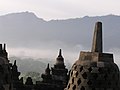 Stupa í Borobudur ber við fjöllin í Java. Öldum saman var hofið gleymt og yfirgefið.