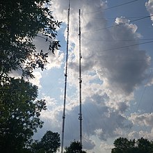 View from the base of two tall broadcast towers