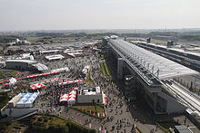 A large grandstand with market stalls behind it.