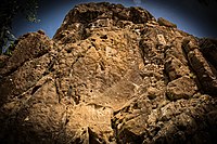 The relief is located on the top of a cliff towering over the village of Sarpol-e Zahab. A second relief (Parthian Empire period) appears below.