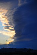 Massive towering vertical cloud arising from behind the San Gabriel mountains, and viewed from the Mojave desert, California