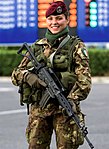 Fallskärsmjägarbaskerns vinröda färg är grunden till de militära baskrarnas rika färgschema. Bilden visar en italiensk kvinna fallskärmsjägare 2006.