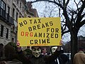 A protester holds a sign calling the church an organized crime front