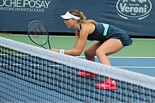 Badosa at the net, in return position at a doubles match at the Mubadala Citi Open, 2024