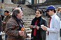 Anonymous members, wearing the black uniform with red tie, discuss Scientology with passers-by.