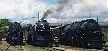 Three steam locomotives on display with one in the middle being operational