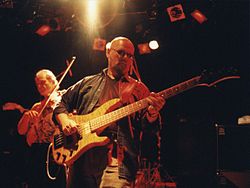Andy West basszusgitáros és Allen Sloan hegedűs egy 1991-es Dixie Dregs koncerten.