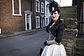 A goth woman wearing a black and white corset over a black blouse and white skirt.