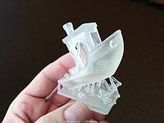 A 3DBenchy printed on a stereolithography (SLA) 3D printer with support material still attached