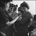 A group of girls around a puppy at a football game