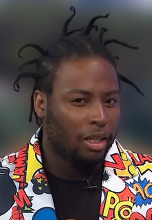 Young Dirty Bastard is an African-American male with stringy hair, wearing a colorful suit