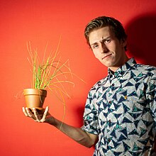 Tristan holding a plant.