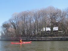 Kayaker in front of a decrepit shack house