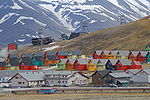 Zdjęcie przedstawia miejscowość Svalbard wraz z domami na tle zaśnieżonych gór
