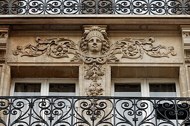 Neoclassical rinceaux with a mascaron of Rue des Vinaigriers no. 57, Paris, designed by E. Escudie, 1882