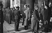 Quisling hilser på Carl Frølich Hanssen på Universitetsplassen i Oslo i 1941. Ellers sees befal fra norsk og tysk arbeidstjeneste.Til høyre Axel Stang og Gulbrand Lunde, minister for folkeopplysning. Foto: Riksarkivet