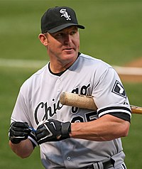 A man in a gray baaseball uniform and black cap