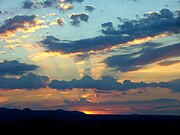 The clouds reflect shadows at sunset, and fan them throughout the sky.