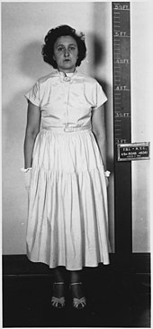 Side- and front-view portrait photographs of woman wearing white apparel. The woman has thick, black, curly hair and maintains an emotionless face