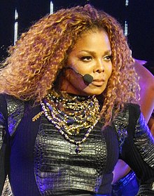 Janet Jackson berambut kerinting memandang sebelah kirinya