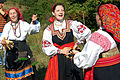 Russian women with treshchotka and Spoon (musical instrument) in their hands. The two women on the right are wearing Sarafans.