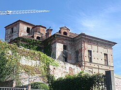 A red-brown brick building sits elevated with a construction crane above it.