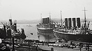 RMS Aquitania seen with one of her running mates, RMS Mauretania (right in front), and the White Star Liner RMS Olympic (far left) at Southampton, early 1920s.