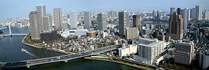 Upper portion of Tsukishima (island neighborhood), Chūō Ward, Tokyo, Japan. Tsukudajima, with its small houses, appears at the forefront. The Sumida River crosses in the foreground; the bridge on the bottom left is the Tsukuda Bridge (Tsukuda Ohashi), above that is the white Chou Bridge (Chuo Ohashi), and above that the blue Eitai Bridge (Eitai-bashi).