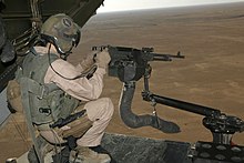 M240 machine gun mounted on V-22 loading ramp with a view of Iraq landscape with the aircraft in flight