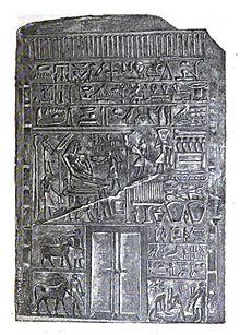Intef Tua duduk, di atas apa yang mungkin merupakan prasasti makamnya CG 20009.[1]