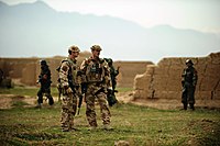 British soldiers wearing desert combat dress including body armour covers and bush hats.