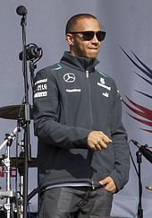 Lewis Hamilton wearing sunglasses looking off to his left