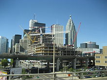 Several skyscraper buildings in background with elevated highway passing in front