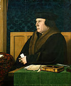 一個都鐸王朝時期戴著帽子和穿著皮毛大外套的男子，坐在辦公桌前。