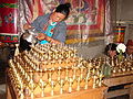 Remplissage des lampes dans un temple bouddhiste