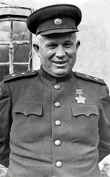 Photographie d'un homme souriant portant un uniforme sur lequel est accroché une médaille en forme d'étoile