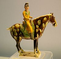 glazurita sancai tombofigureto de la Tang dinastio montranta surĉevalan figuron