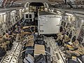 Photograph of the inside of a cargo jet, containing people in military field uniforms, equipment, and trucks (from Tropical cyclone response)