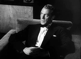 Screen capture of Gary Cooper sitting down