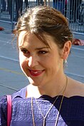 A 38-year-old woman with brown hair smiles to the left of the camera.