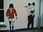 Två poliser som kysser varandra, medan fotbollsspelaren George Best (Manchester United) tittar på, Brighton.