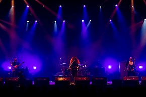 Coheed and Cambria performing in 2016 Left to Right: Travis Stever, Claudio Sanchez, Josh Eppard (obscured, on drums), Zach Cooper