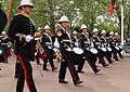 A band during the funeral procession of Elizabeth II (flanked by a Director of Music as a marker). The side, tenor and bass drums are wrapped in black cloth during a funeral procession.