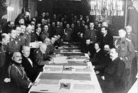 Black white photo of people sitting on a long table