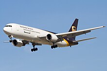 Side quarter view of UPS twin-engine freighter in flight, with extended gear