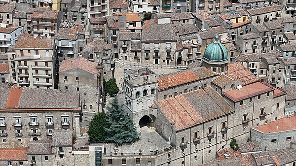 Immagine aerea del Duomo di San Nicola di Bari inseriti nel contesto paesaggistico del borgo. Si nota la cupola, il campanile e la piazza con il suo belvedere.