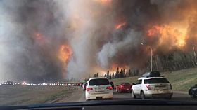 Résidents de Fort McMurray en cours d'évacuation le 3 mai 2016 le long de la Route 63 alors que le feu envahit la zone.